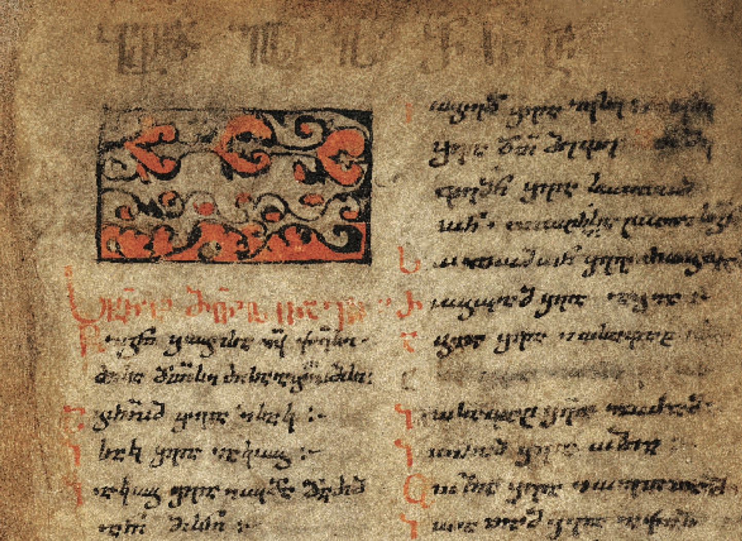 A worn parchment page written in two columns of dark Georgian script, with an ornamental red-and-black headpiece and red initials down the margins. Fainter, older writing shows through underneath the later text.