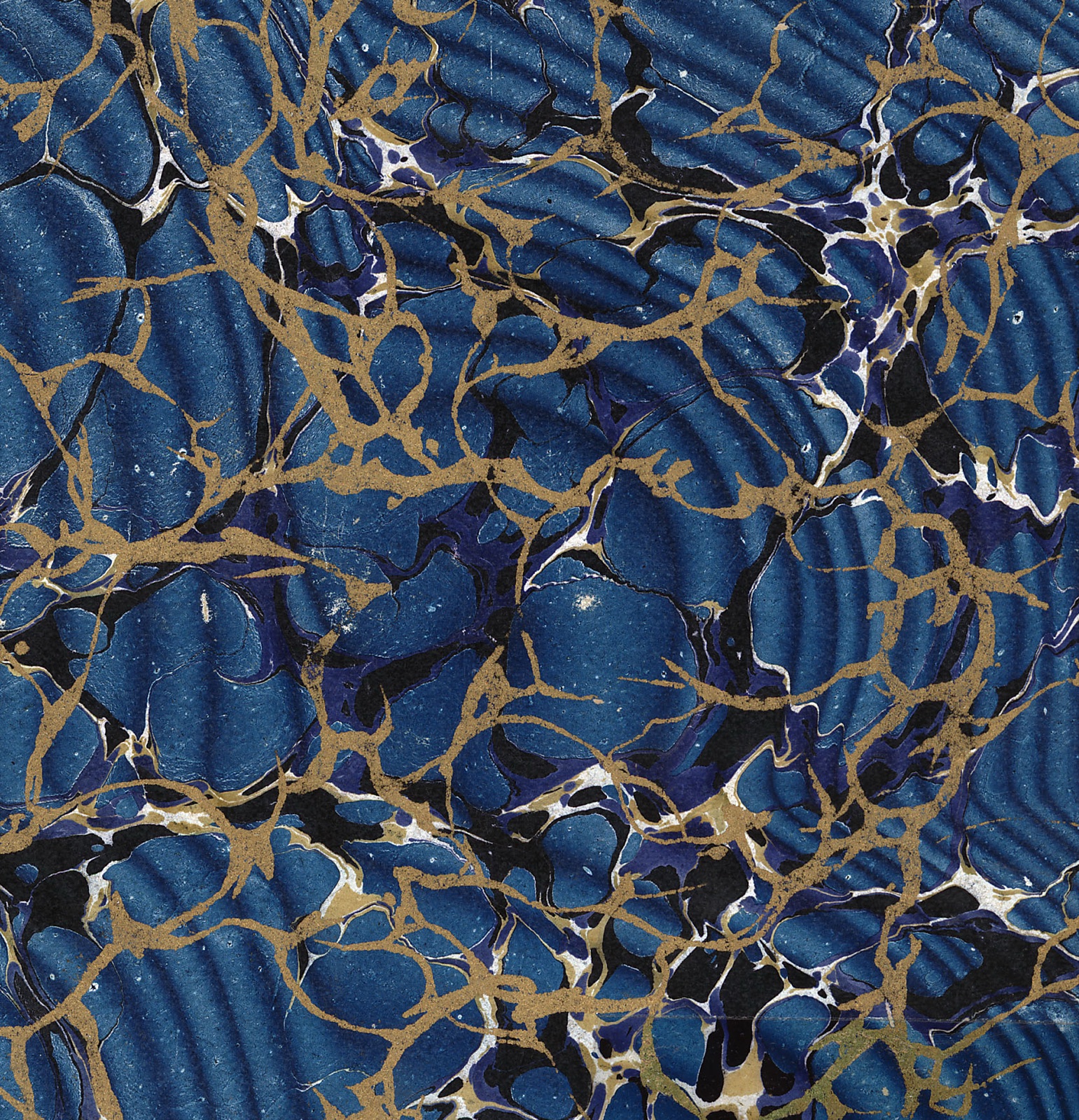 Swirled marbled paper in deep blue and gold, the combed, vein-like pattern of a 19th-century book cover.