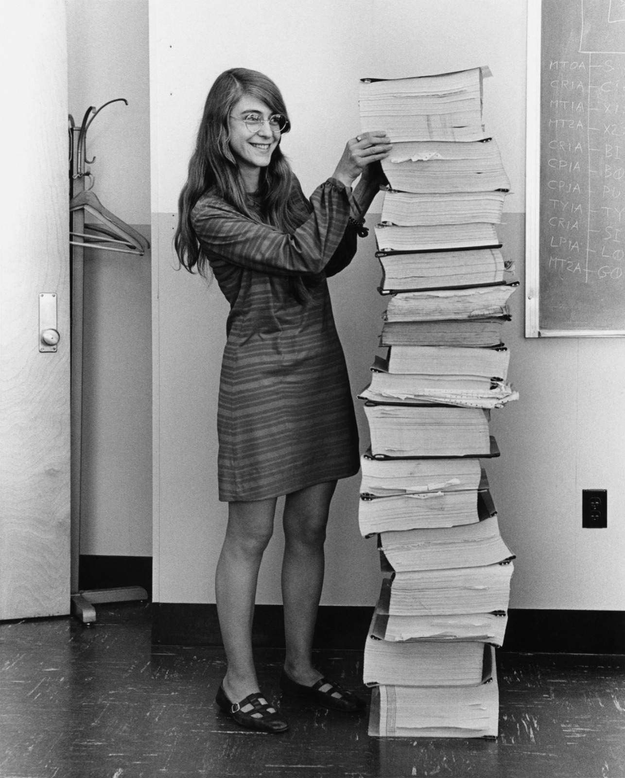 Margaret Hamilton standing beside a stack of Apollo guidance software listings as tall as she is, at the MIT Instrumentation Laboratory in 1969.